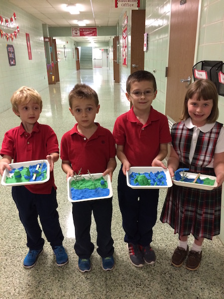 Students show off their landform dioramas