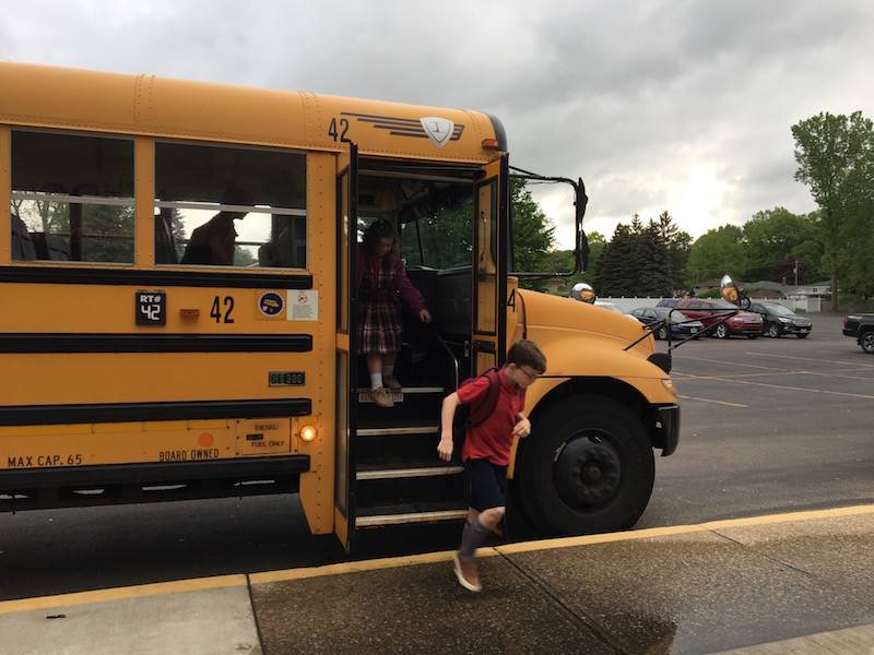 students getting off buses