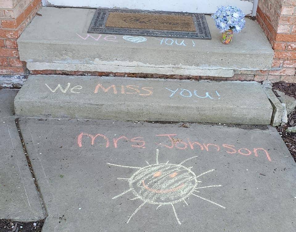 chalk drawing of a sun reading we miss you mrs johnson