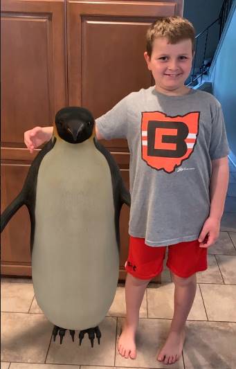 boy standing next to penguin