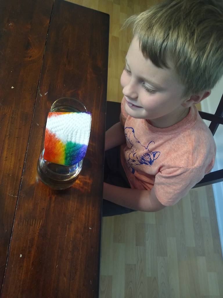 boy looks at the rainbow he made