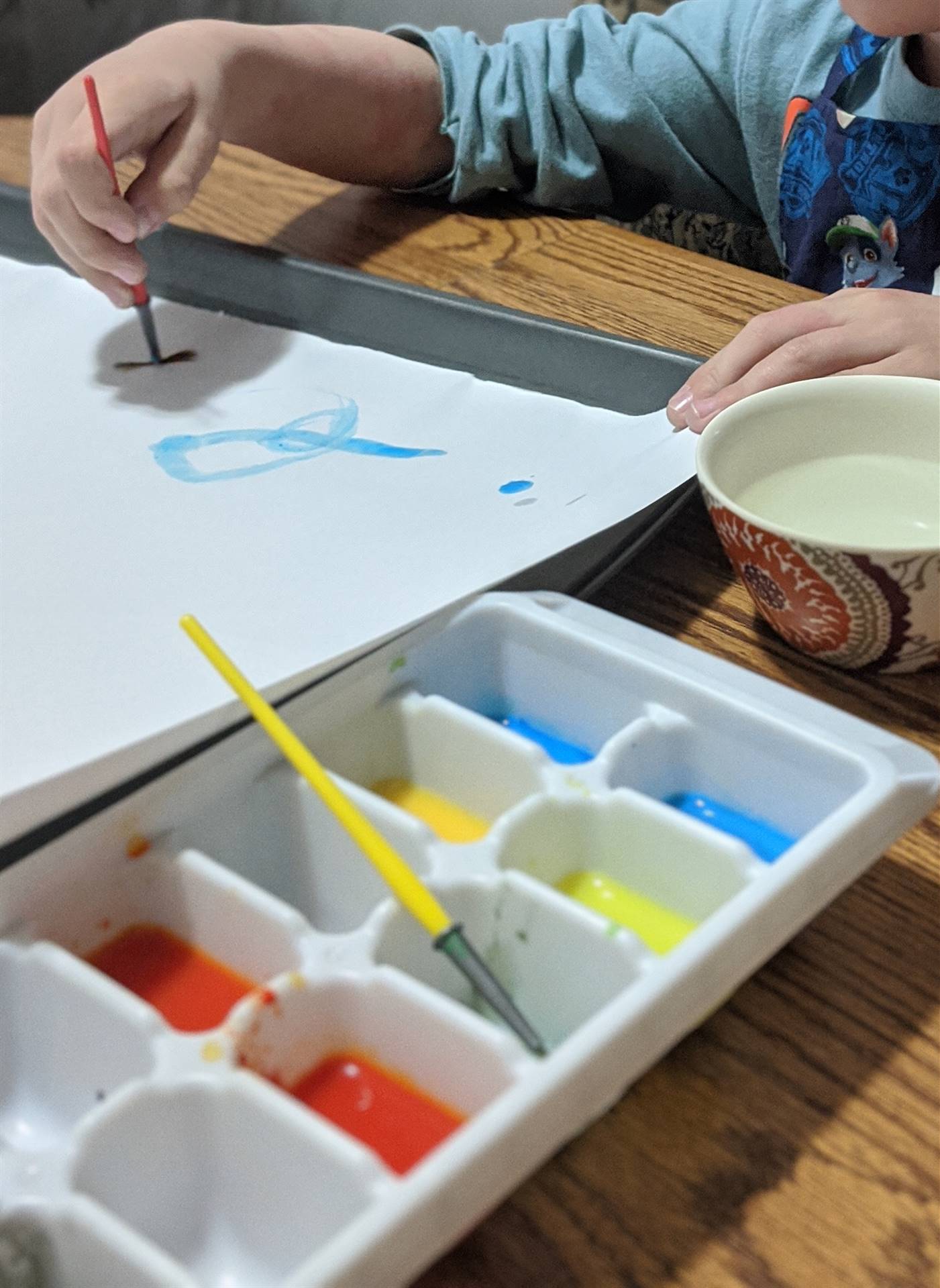 student painting using an ice cube tray as the color palette