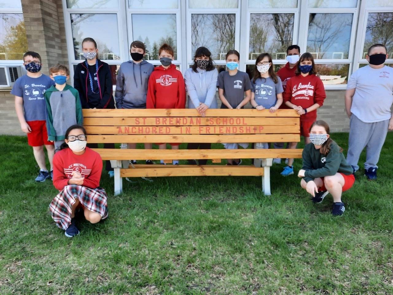 students pose with buddy bench created in STEM class