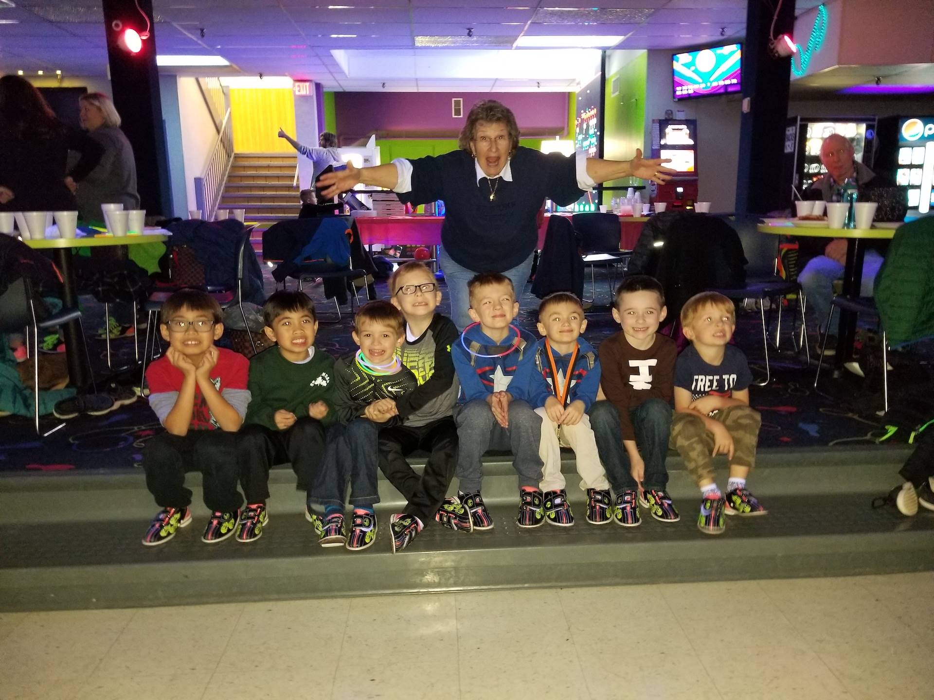 Mrs. O poses with boys at mother son bowling
