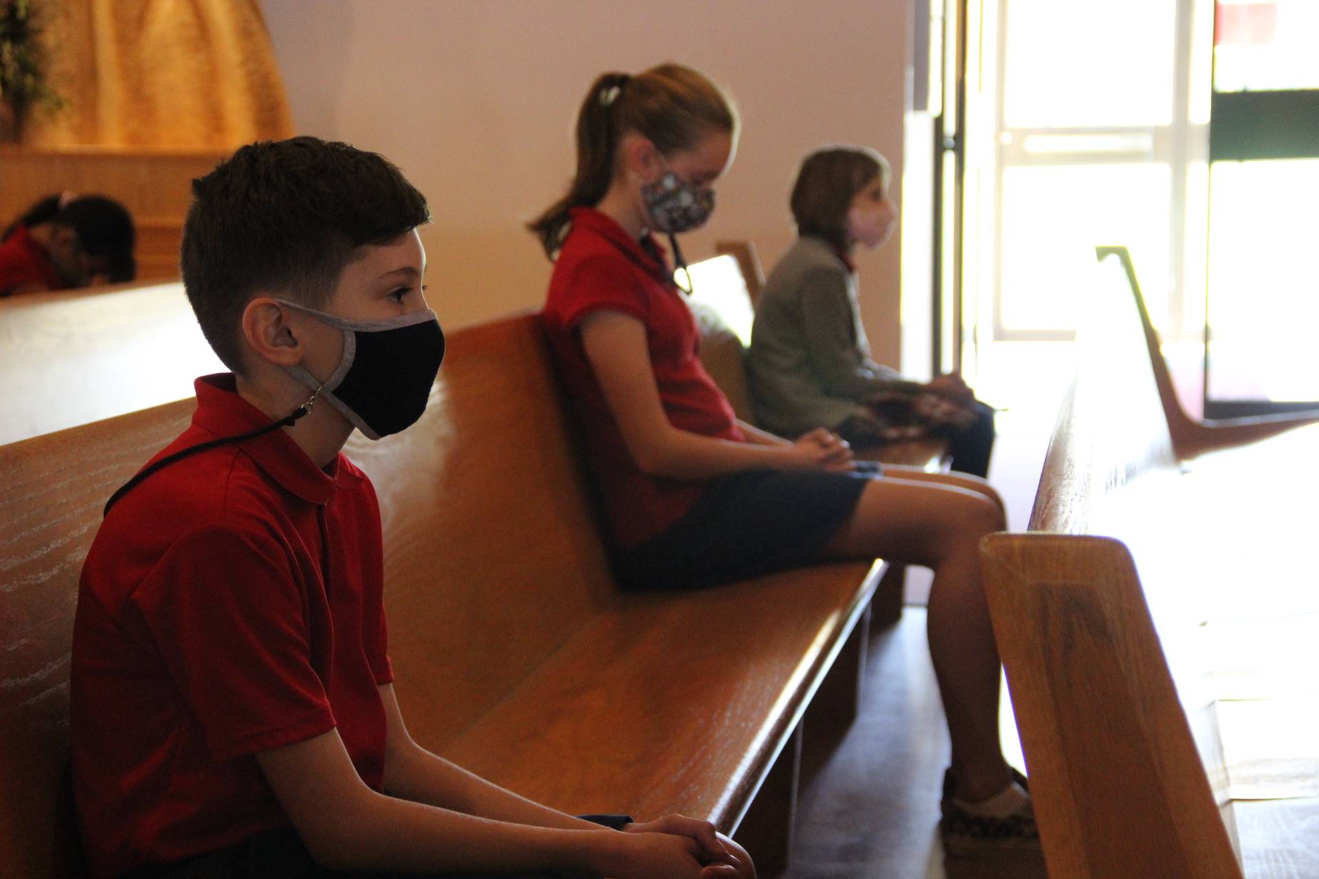 students sit in prayer during adoration