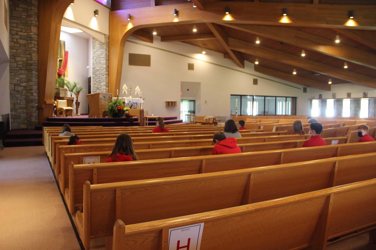 students pray in church during adoration