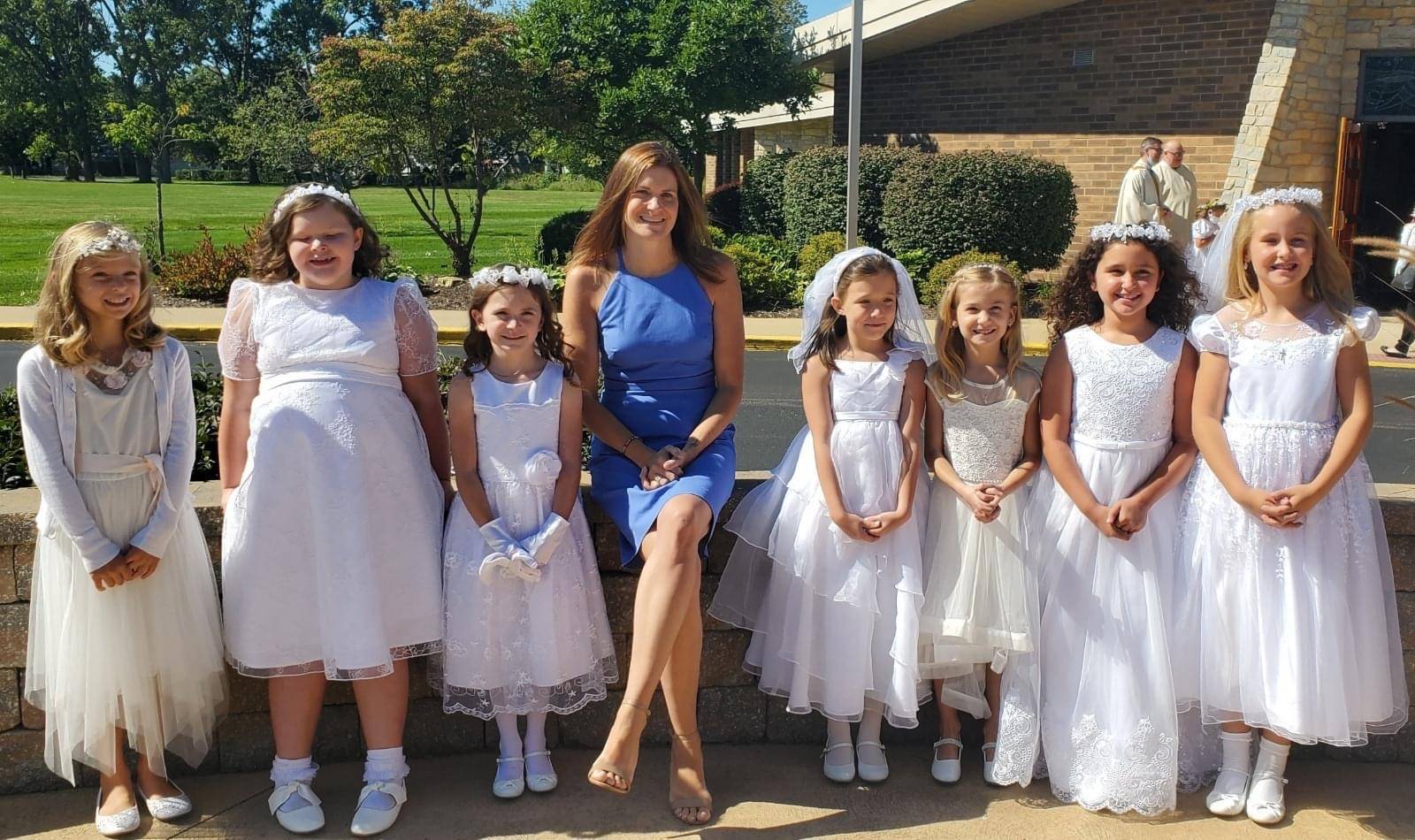 fall communion class delayed from COVID, teacher and girls in white dresses pose for a picture