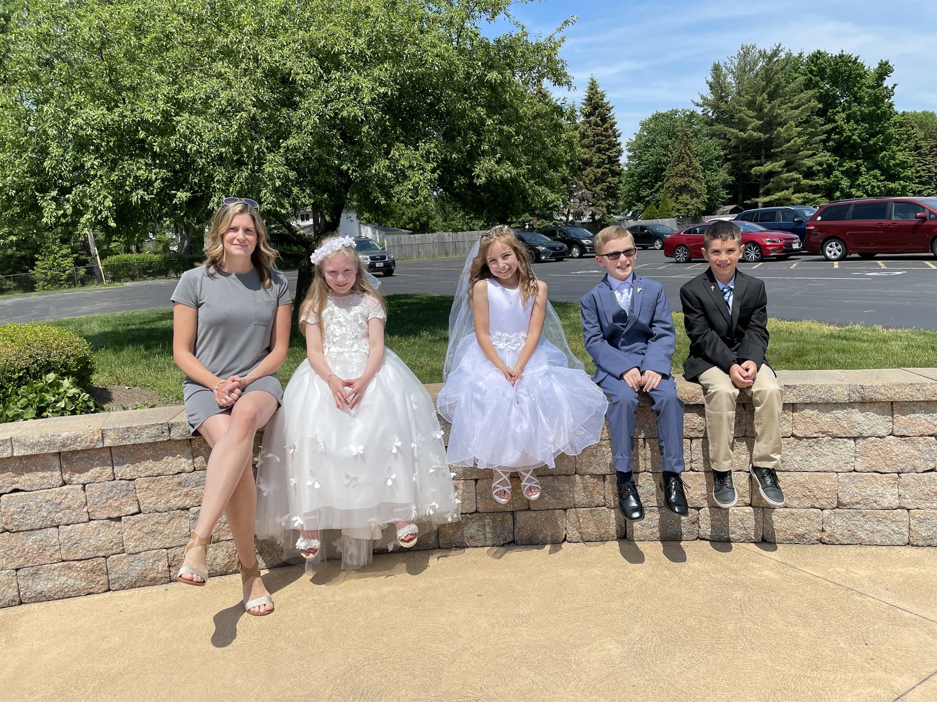 spring communion class teacher and girls in white dresses boys in suits pose for a picture