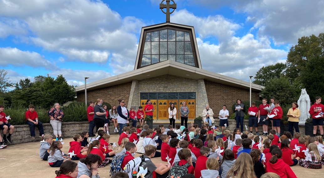 students gather for a picture in the our lady of knock prayer garden