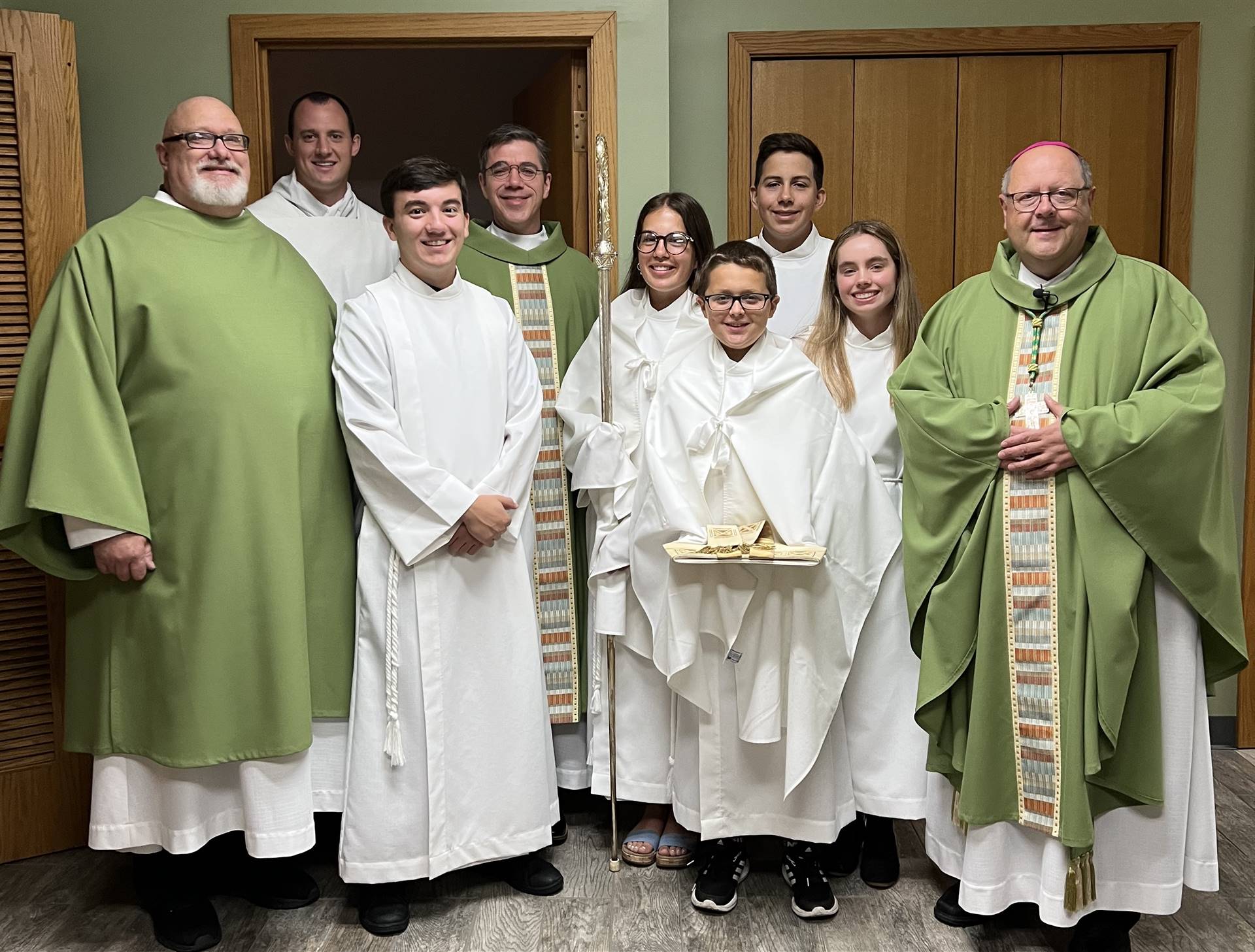 servers, seminarians, deacon, priest, all pose with bishop malesik