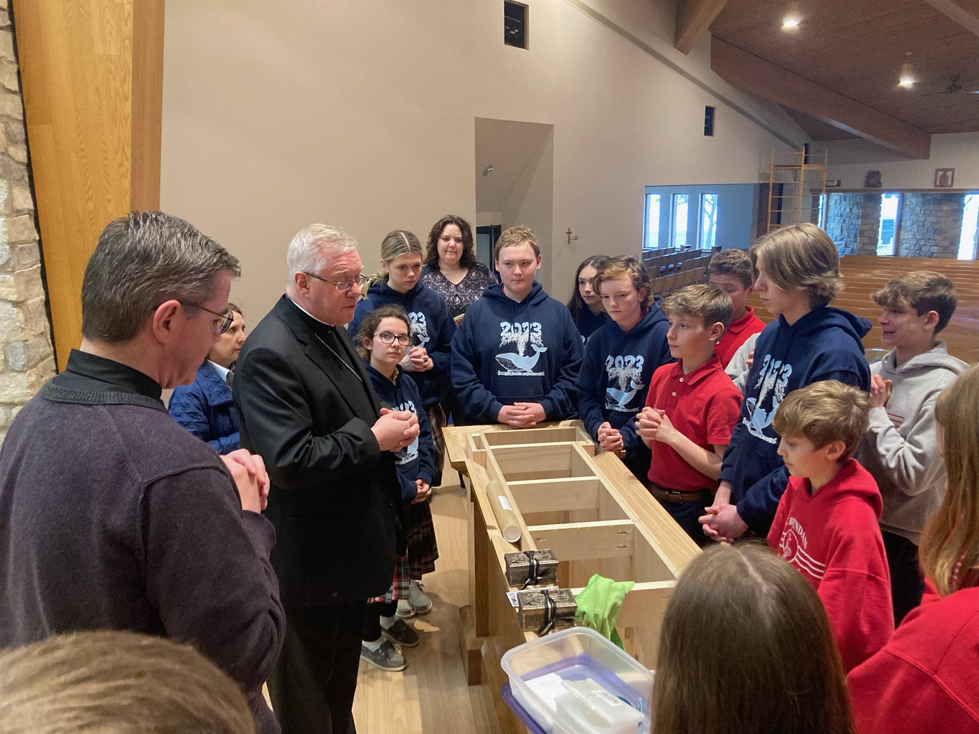 Bishop Woost and Fr. Tom explain to 7/8 graders about the relics