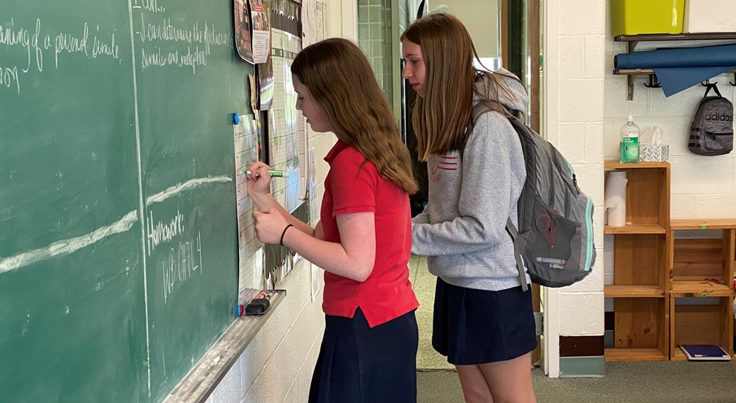 7th grade girls write on the chalk board