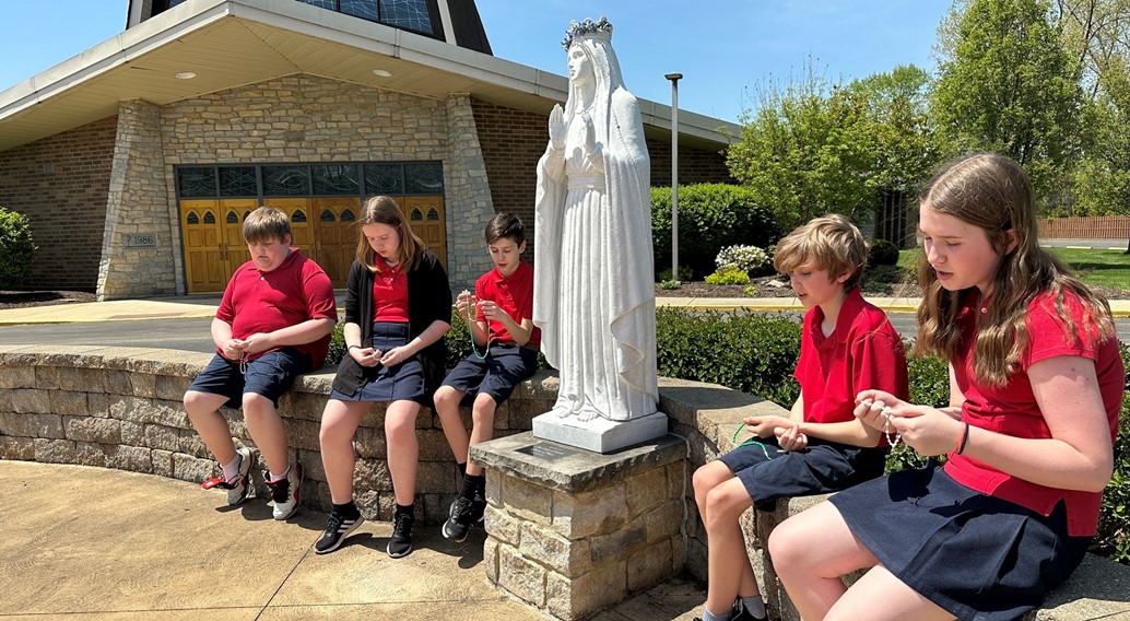 7th grade prays the rosary in the prayer garden