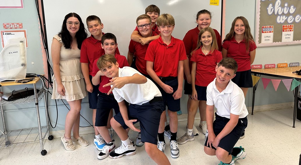 6th grade poses for a picture with Miss Mostoller