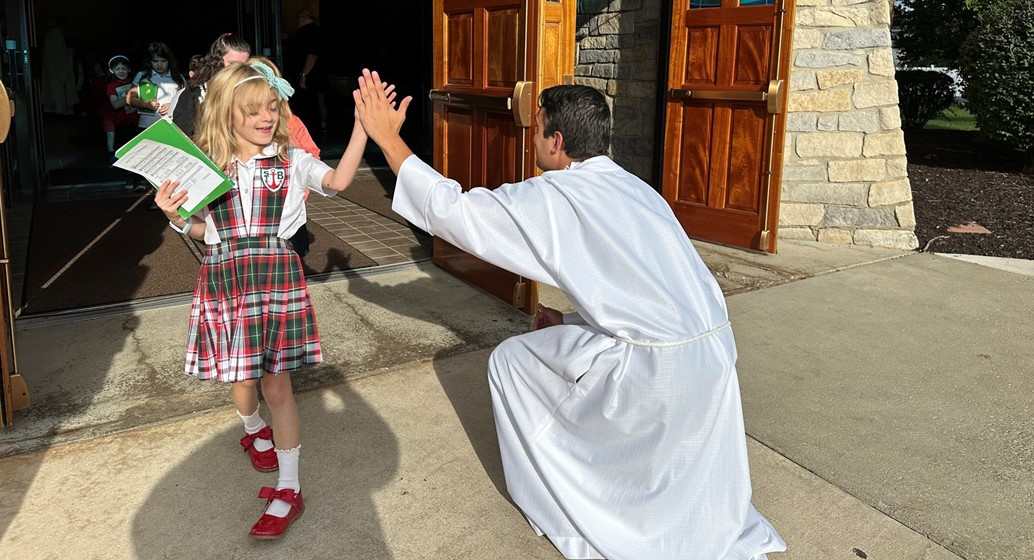 Cam high fives the students leaving mass