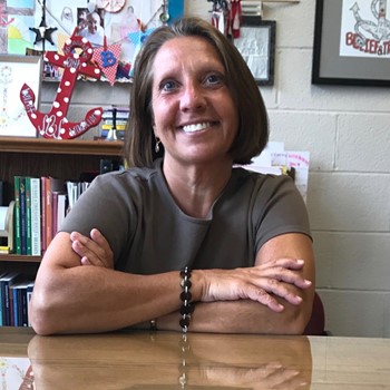 Miss Onacila, Principal of St. Brendan School, sits behind her desk